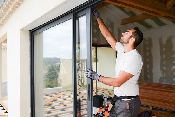 man installing bay window in a new house construction site